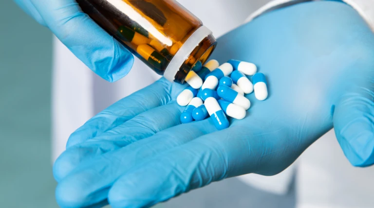 front-view-young-man-white-shirt-blue-gloves-taking-pills-blue-space.webp