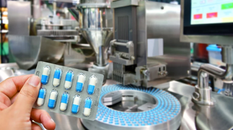 hand-holding-blue-capsule-pack-medicine-pill-productionline.webp