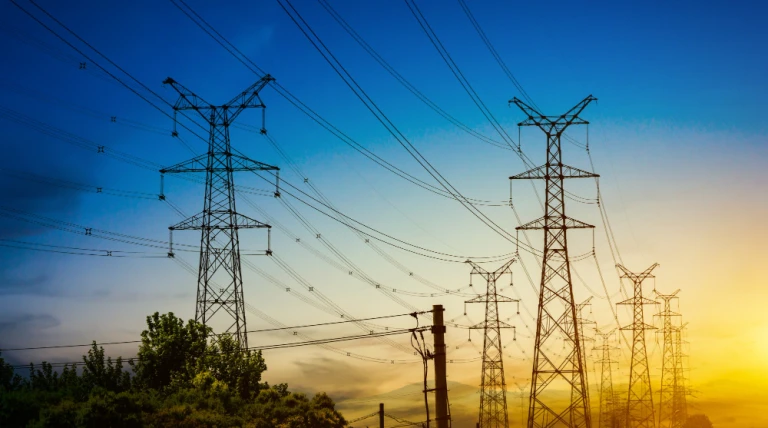 sun-setting-silhouette-electricity-pylons.webp